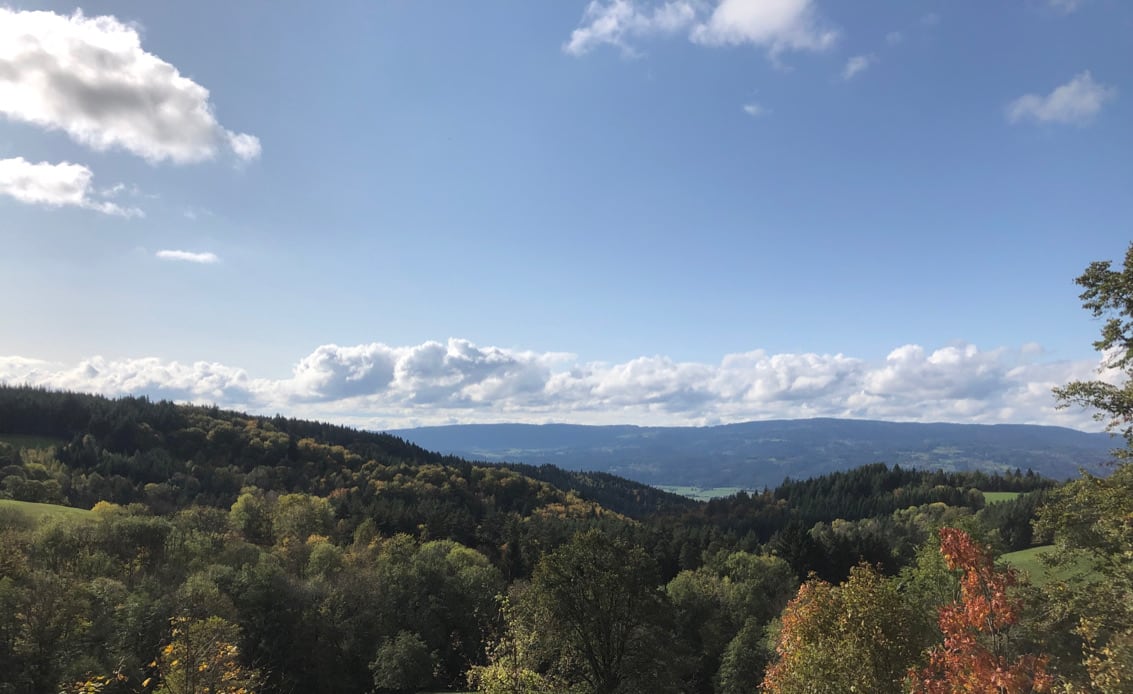 view of mountains in autumn colours and cloudy blue sky